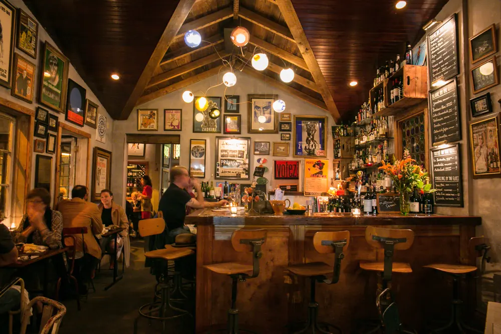 The dining room at N7, with a wood-beamed ceiling, framed art and a bar.