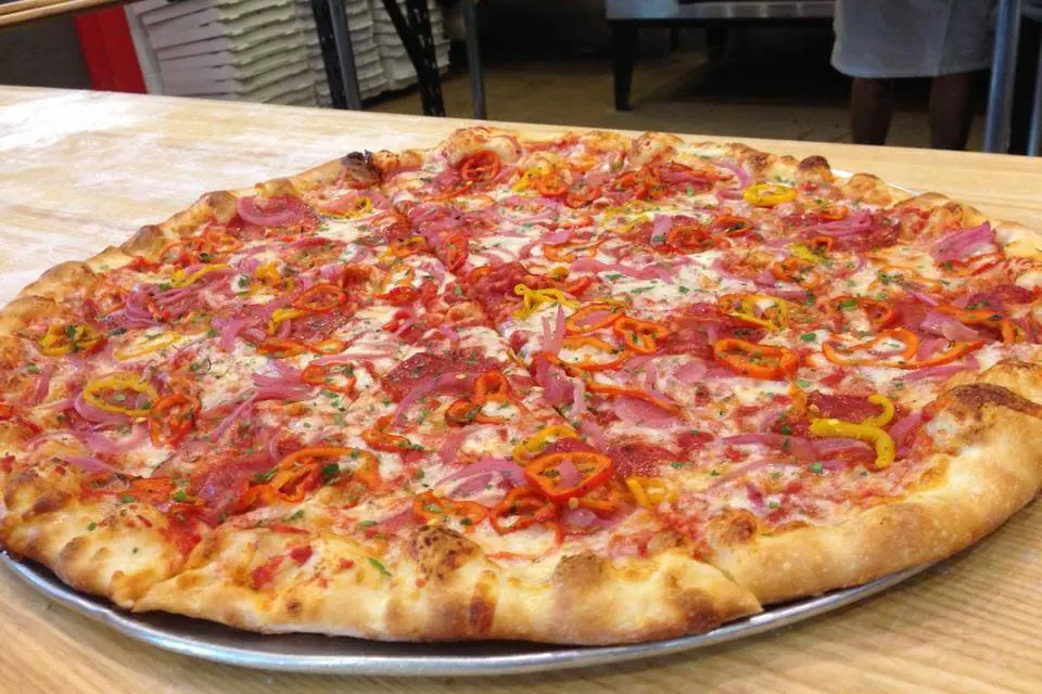A whole pizza with toppings on a metal pan.
