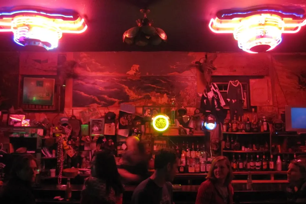 The bar at Saturn Bar, lit in red with neon signs.