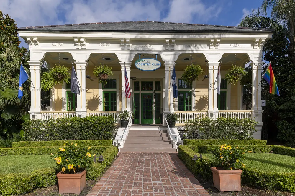 The Country Club, a white house with columns and a brick path through the garden.