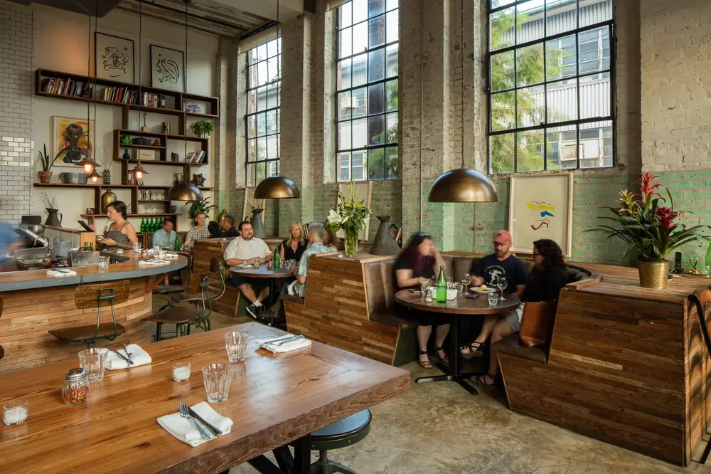 The high-ceilinged dining room at Paladar 511, with tall windows and wood tables.