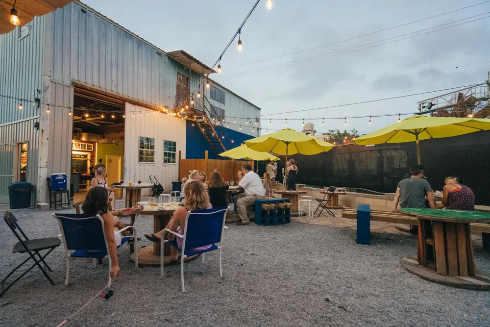 The yard at Parleaux Beer Lab, with yellow umbrellas, picnic tables and string lights.