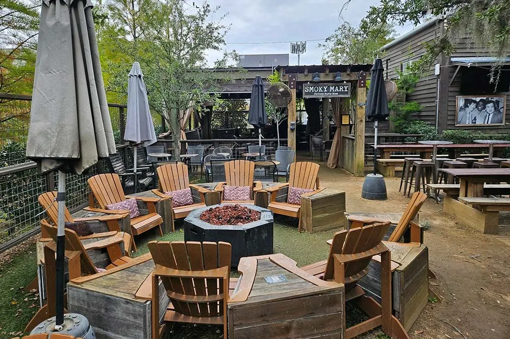 Adirondack chairs around a fire pit in the beer garden at Wrong Iron on the Greenway.