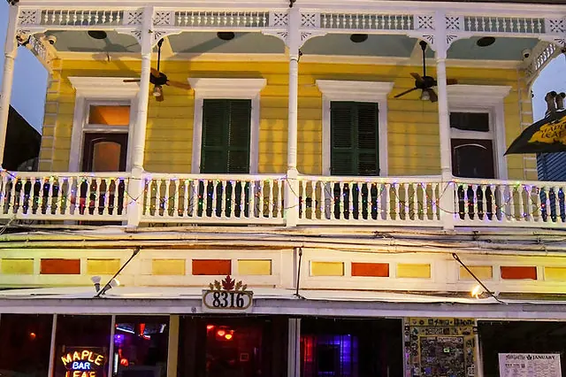 The Maple Leaf Bar, a yellow two-story building with a balcony on Oak Street.